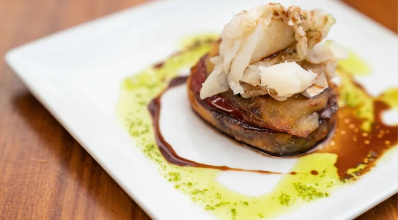 A plated salt cod pintxo with parsley oil, served on a private pintxos tour in San Sebastian
